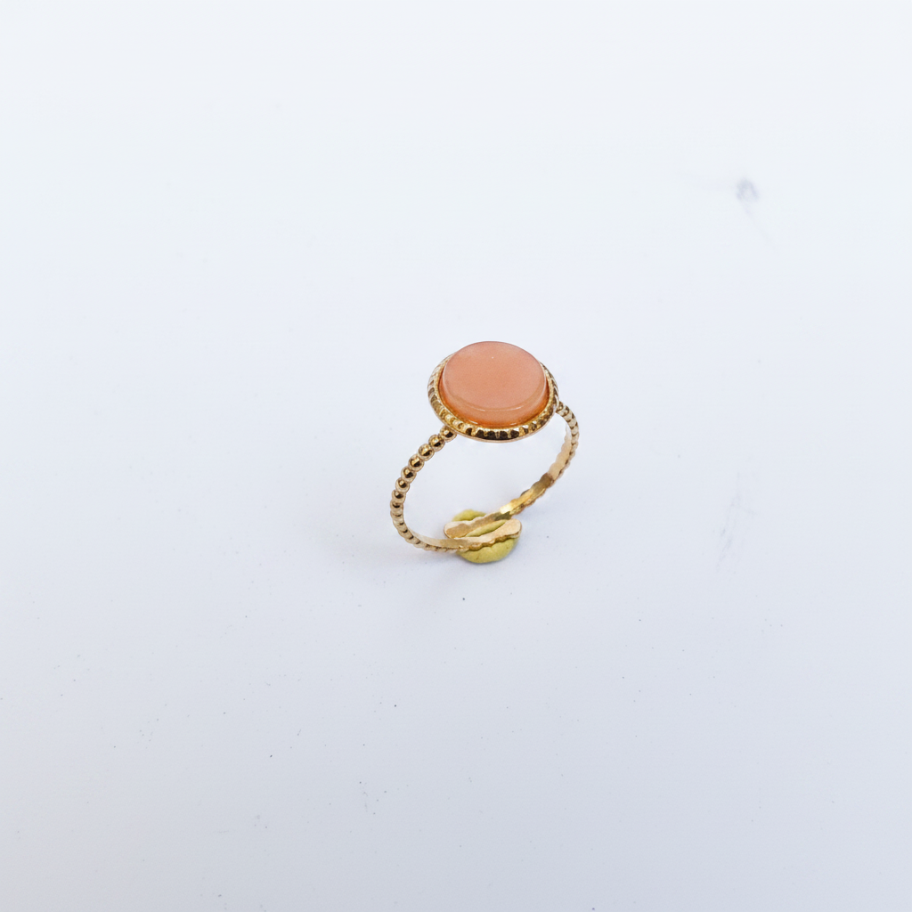 Bague dorée pierre pêche trois-quarts fond blanc