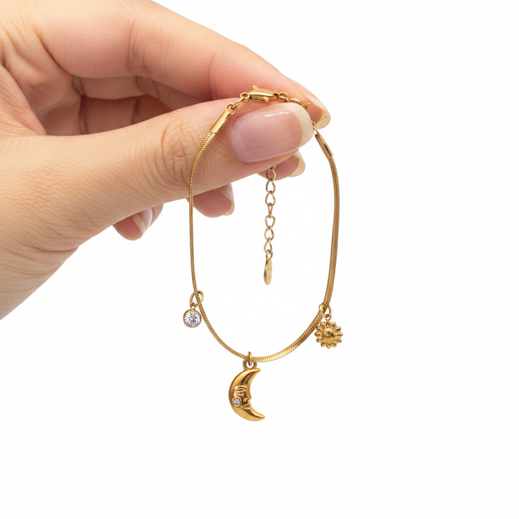 Bracelet charm lune soleil tenu en main fond blanc