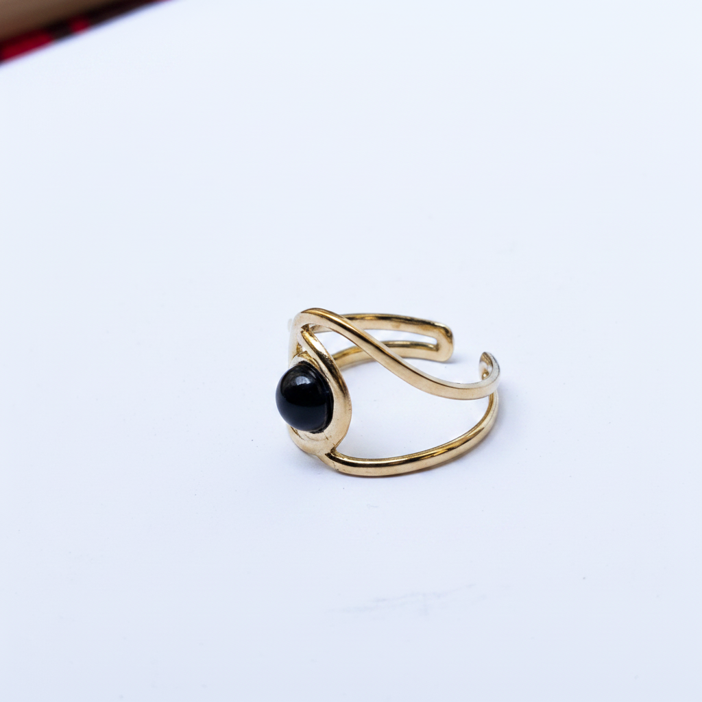 Bague dorée double anneau pierre noire angle fond blanc