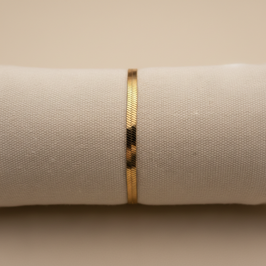 Bracelet chaîne plate dorée sur support lin