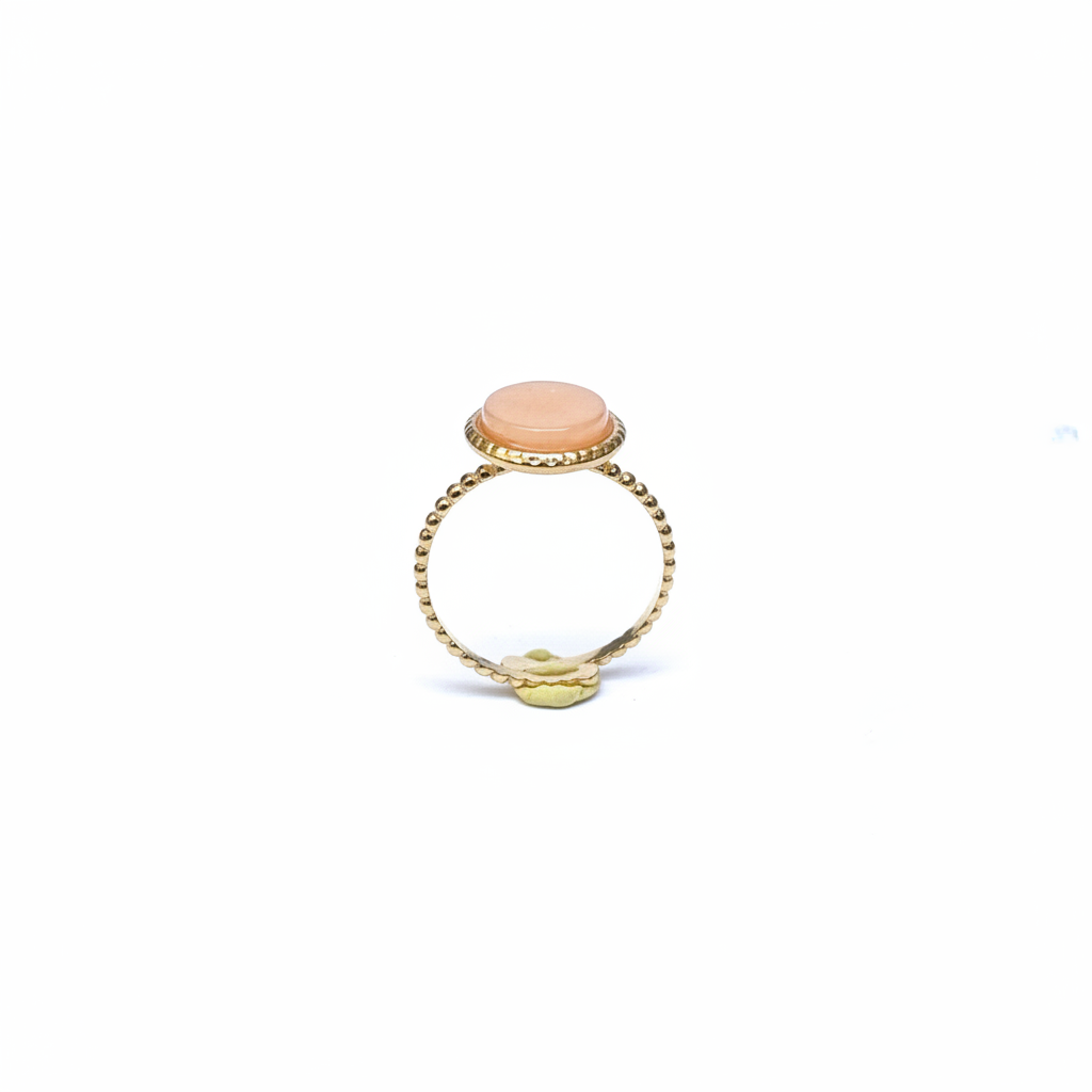 Bague dorée pierre pêche face fond blanc
