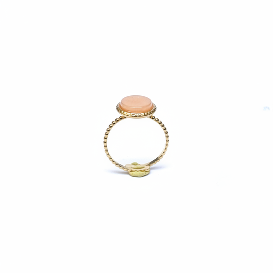 Bague dorée pierre pêche face fond blanc