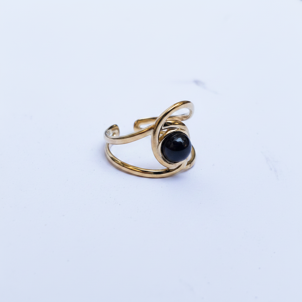 Bague dorée double anneau pierre noire trois-quarts fond blanc