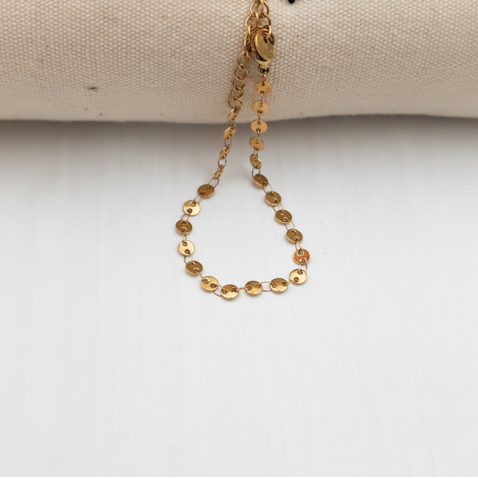 Bracelet sequins dorés suspendu fond blanc