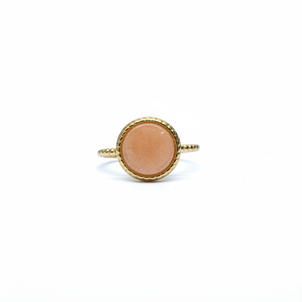 Bague dorée pierre pêche face rapprochée fond blanc