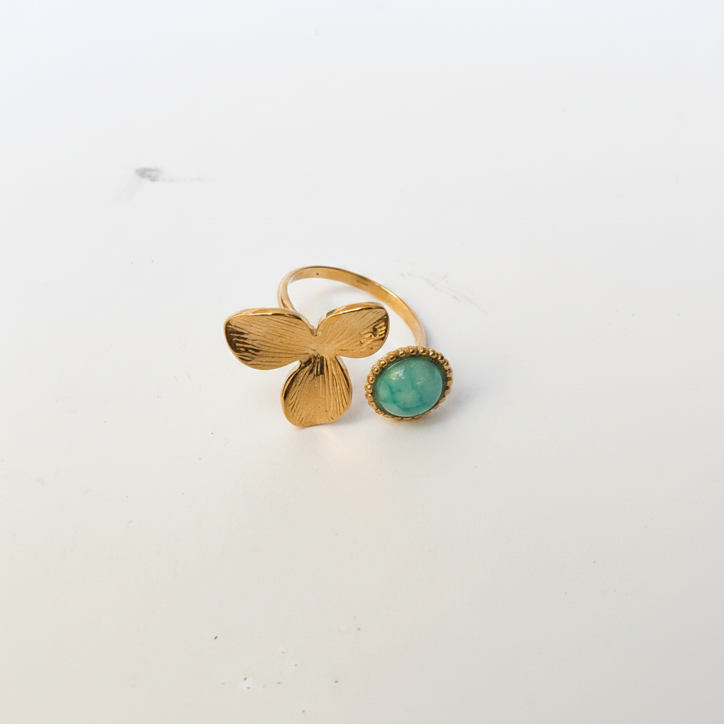 Bague fleur dorée turquoise dessus fond blanc