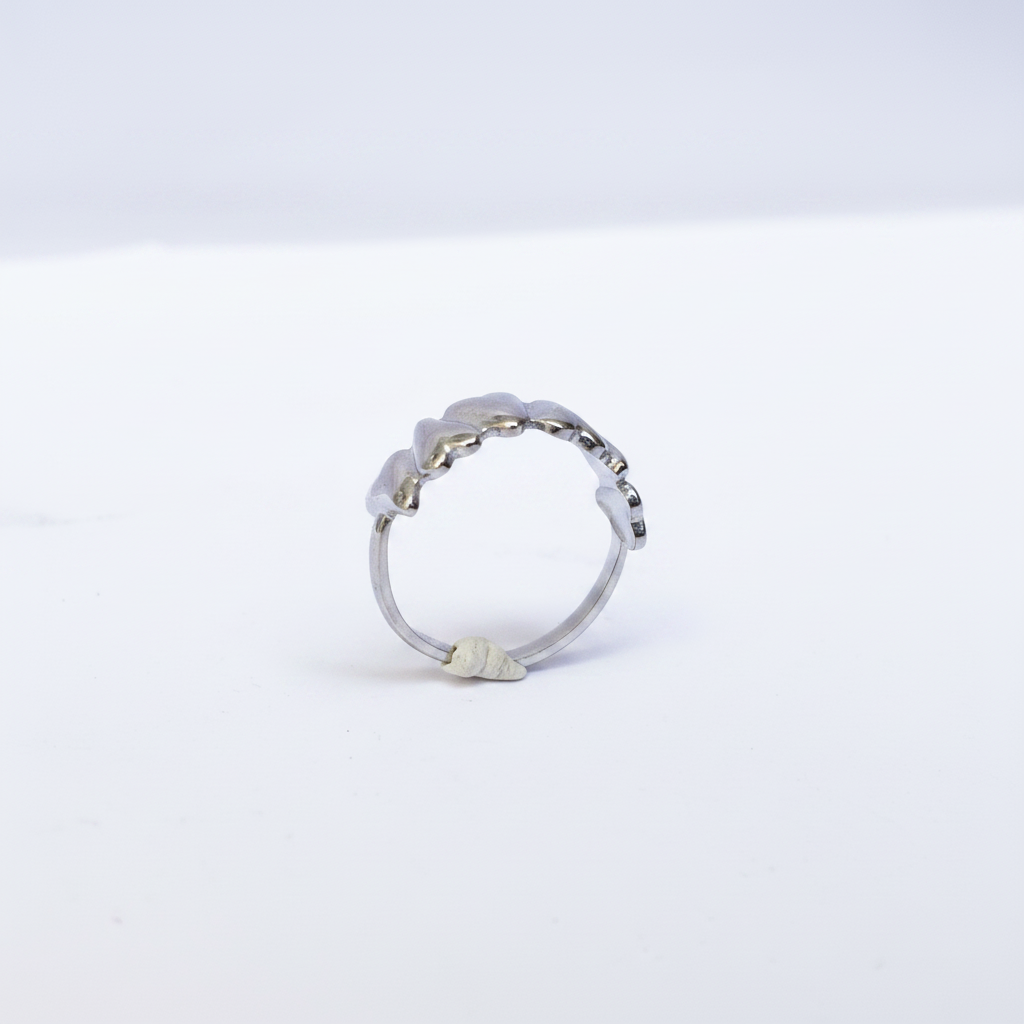 Bague multi-cœurs argentée dessus fond blanc