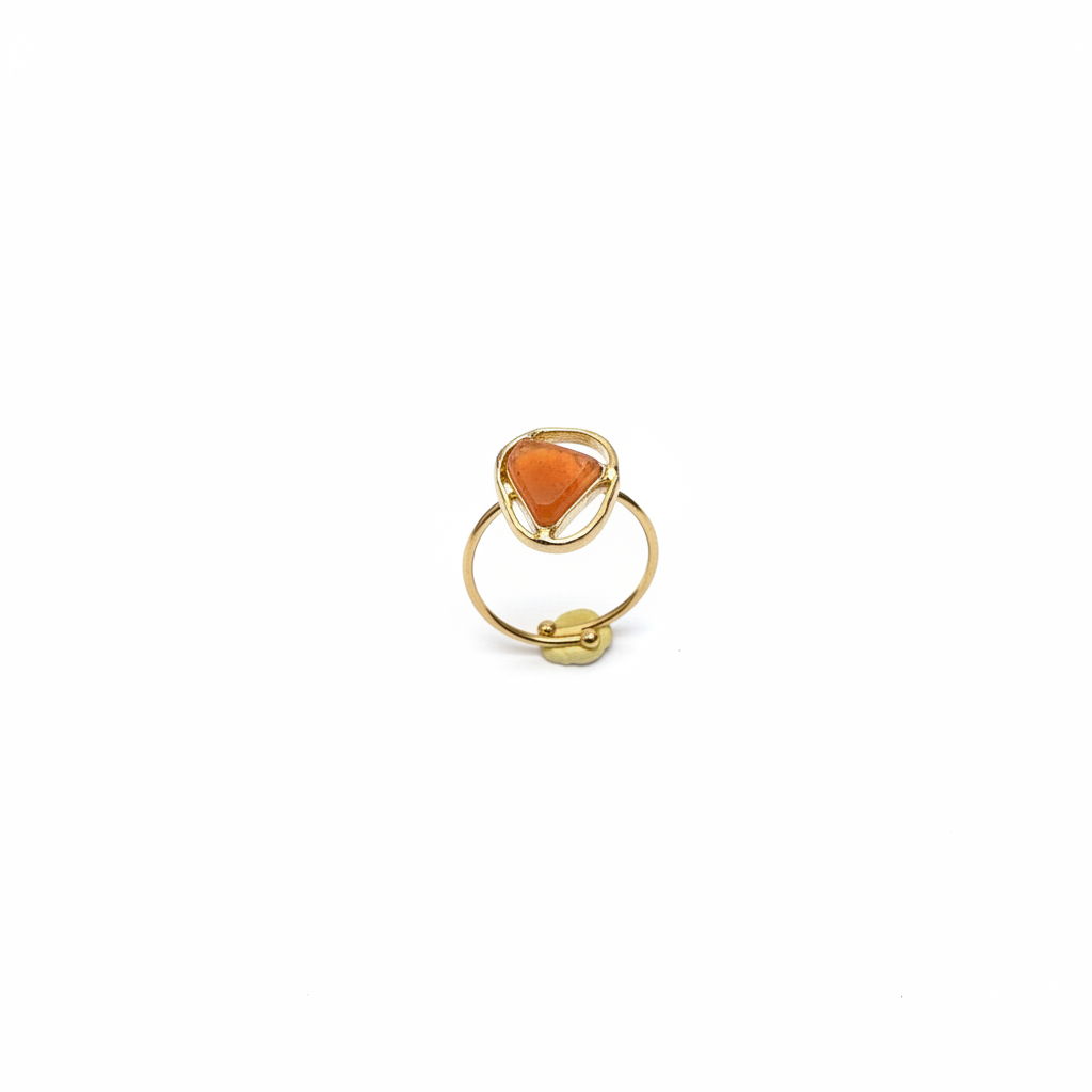 Bague dorée cornaline dessus fond blanc